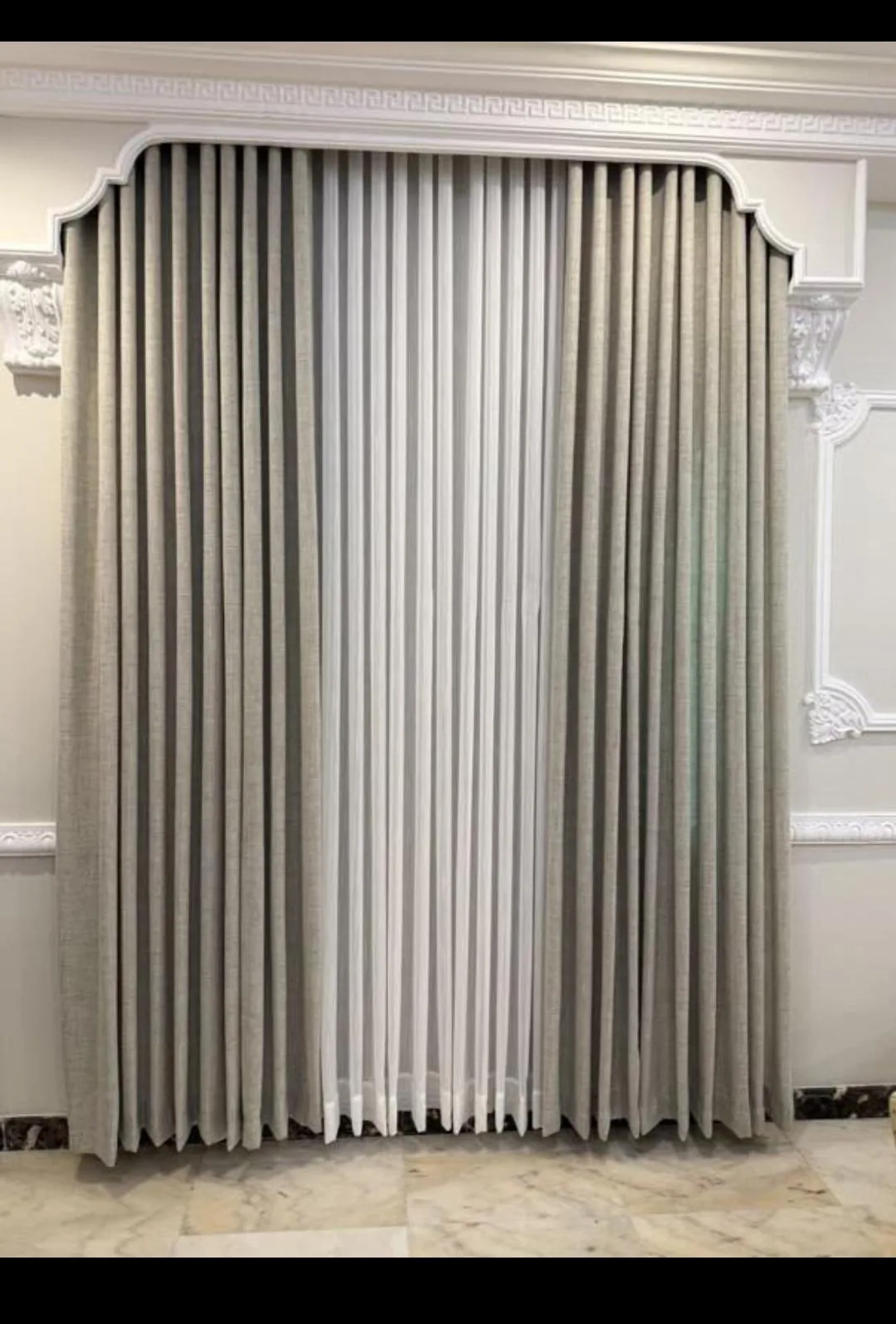 Floor-to-ceiling grey wave curtains in a Riyadh living room